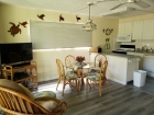 Living room with 40 inch TV, dining area and new queen sofa bed